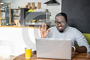 An African-American guy is sitting at the table in cozy cafe