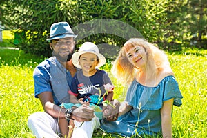 African American happy family: black father, mom and baby boy on nature. Use it for a child