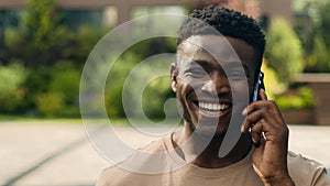 African American happy laughing smiling joyful man ethnic talking mobile phone guy laugh smile walking in city answer