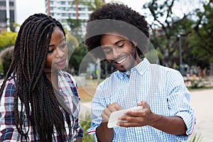 African american hipster man showing pictures at phone