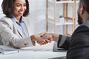 African American hiring manager shaking hand of vacancy candidate during employment interview in office