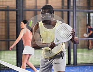 African American hitting backhand during paddle match in close court