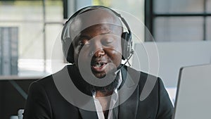 African American hr manager recruiter male teacher coach consultant wears headphones with microphone talk at camera