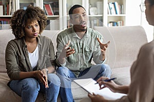 African american husband and wife fighting while visiting psychologist