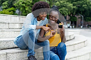 African american influencer posting message with mobile phone photo