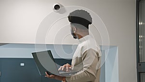 African american installer sets up security camera in office