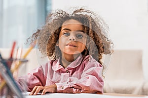 african american kid drawing with color pencils in