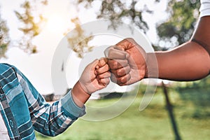 African American kid fist-bumps hand of his dad