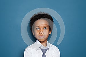 African American kid school boy pupil 6 years old on blue backgroung portrait