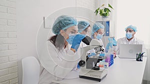 African American laboratory assistant looking through a microscope