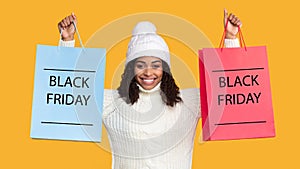 African american lady holding shopping bags with black friday text