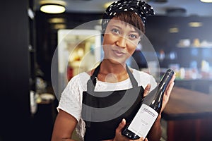 African American lady presenting a bottle of wine