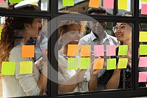 African American leader with team writing ideas on sticky papers