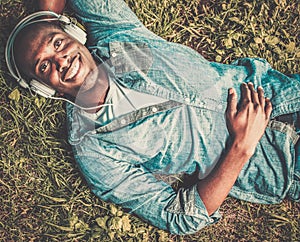 African american listens music in a park