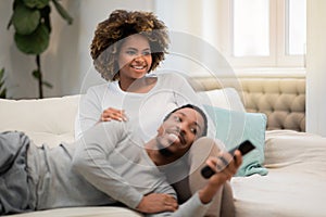 African american lovers watching TV show, home interior