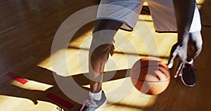 African american male basketball player practicing dribbling ball