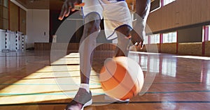 African american male basketball player practicing dribbling ball