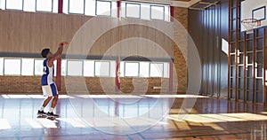 African american male basketball player practicing shooting with ball