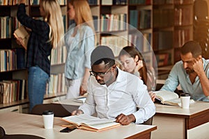 African american male college studen preparing for exams in the library.