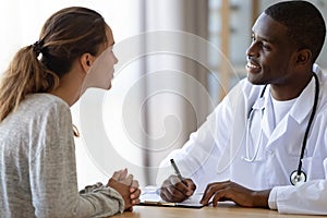 African American male doctor consulting female patient