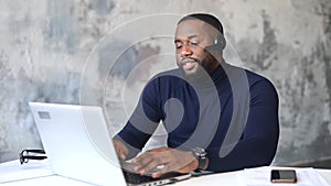 African-American male employee using laptop for video call indoor