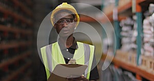 African American male factory worker at a factory looking and smiling to the camera