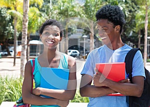 African american male and female student walking on campus