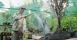 African american male gardener watering plants at garden center