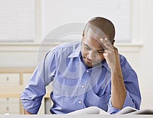 African American male looking at drawings.