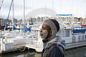 African American male model pondering at a boat marina