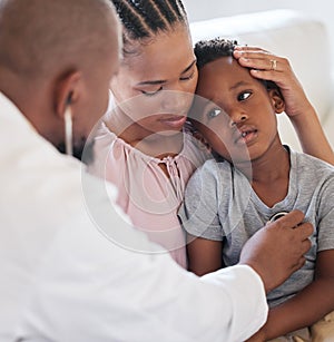 African american male paediatrician examining sick boy with stethoscope during visit with mom. Doctor checking heart