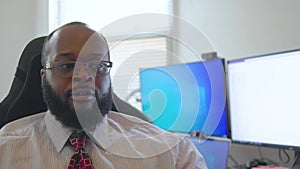 African American male with red tie is sitting at his at home office working