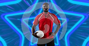 African american male rugby player holding rugby ball against neon star shapes in seamless pattern