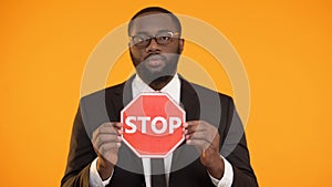 African-american male showing stop sign, antiracism campaign, social equality