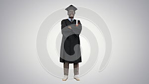 African american male student in graduation robe folding arms wi