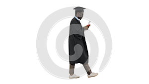 African american male student in graduation robe texting on the