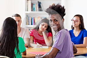 African american male student learning with group of students