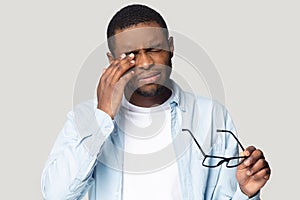 African American male take off glasses suffering from headache