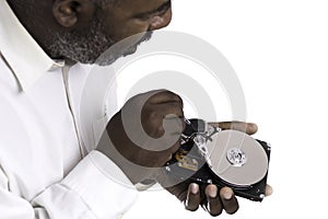 African American Male technician hand holding and working on  computer hard drive with screwdriver