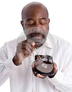 African American Male technician hand holding and working on computer hard drive with screwdriver