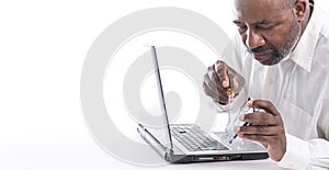 African American Male technician holding hard drive in front of computer laptop