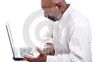 African American Male technician holding hard drive and looking at computer laptop