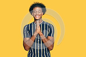 African american man with afro hair wearing casual clothes begging and praying with hands together with hope expression on face