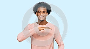 African american man with afro hair wearing casual clothes gesturing with hands showing big and large size sign, measure symbol