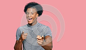 African american man with afro hair wearing casual clothes pointing fingers to camera with happy and funny face