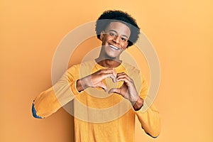 African american man with afro hair wearing casual clothes smiling in love doing heart symbol shape with hands