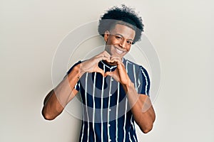 African american man with afro hair wearing casual clothes smiling in love doing heart symbol shape with hands