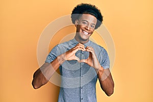 African american man with afro hair wearing casual clothes smiling in love doing heart symbol shape with hands