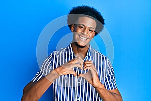 African american man with afro hair wearing casual clothes smiling in love doing heart symbol shape with hands