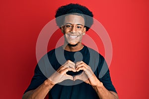 African american man with afro hair wearing casual clothes smiling in love doing heart symbol shape with hands